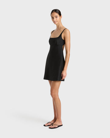 Side view of Bormio Exposed Back Mini Dress Black, open back and clean lines in structured cotton